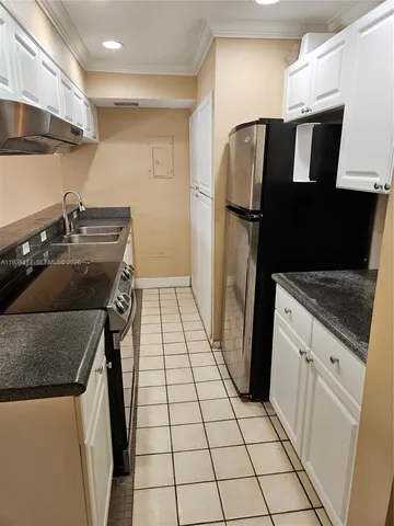 a kitchen with a refrigerator and a sink