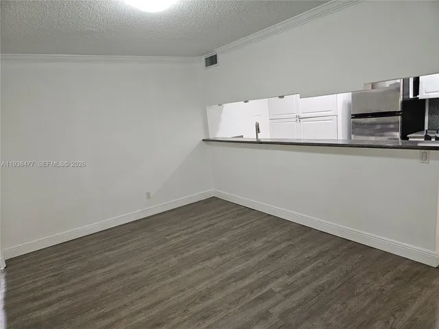 a view of a refrigerator in kitchen and wooden floor