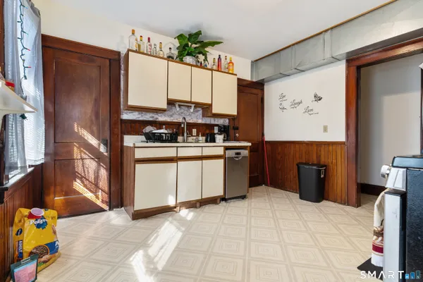 a kitchen with stainless steel appliances wooden floor and a refrigerator