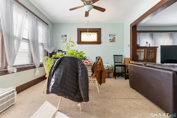 a dining room with furniture and a potted plant