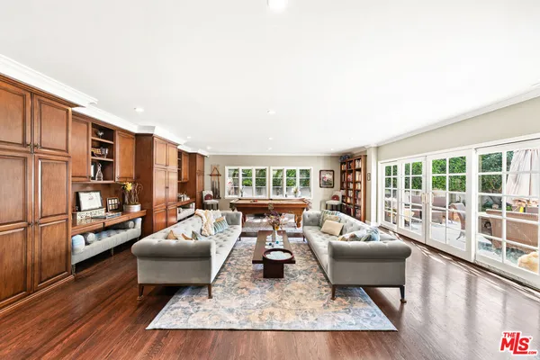 a spacious bedroom with a bed a couch and wooden floor