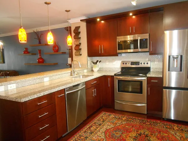 a kitchen with stainless steel appliances granite countertop a stove a sink and a microwave