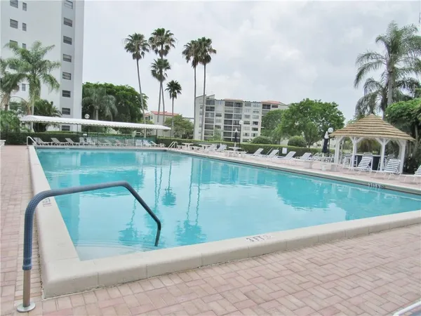 a view of a swimming pool with a chair and a garden