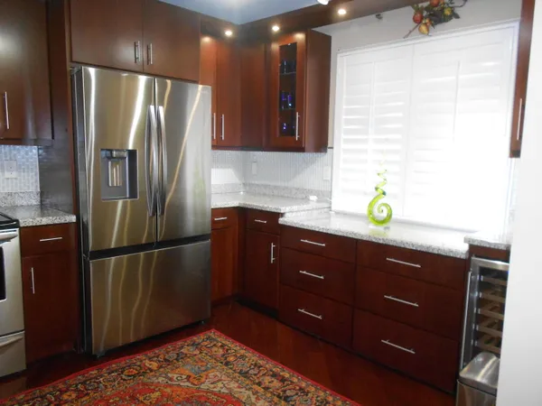 a kitchen with stainless steel appliances granite countertop a refrigerator and a sink