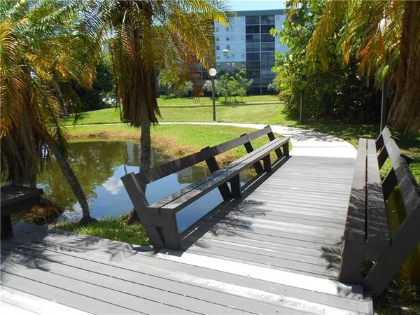 a view of a park with swings and a palm tree