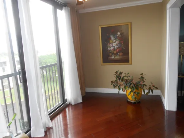 a view of a hallway with wooden floor and a potted plant
