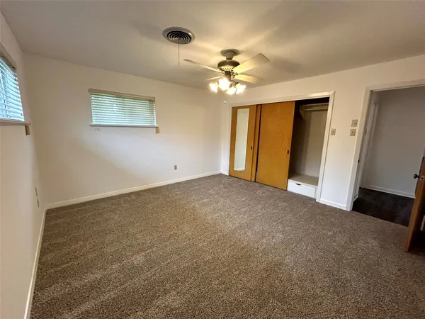 a view of an empty room with a chandelier fan