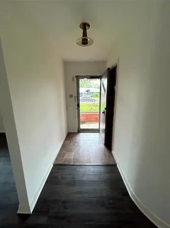 a view of hallway with wooden floor