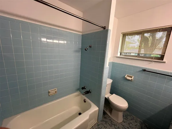 a bathroom with a toilet and shower
