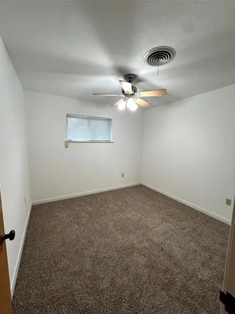 an empty room with a chandelier fan