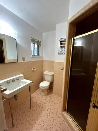 a bathroom with a sink a toilet and mirror