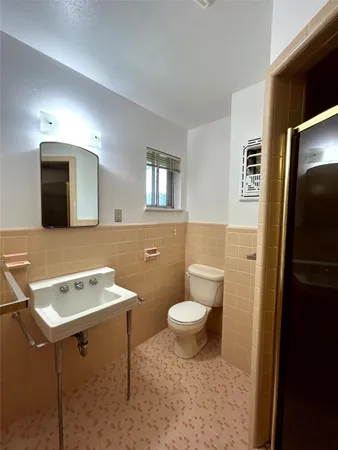 a bathroom with a toilet sink and mirror