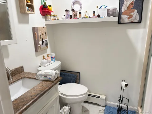 a bathroom with a granite countertop sink a toilet and a shower curtain