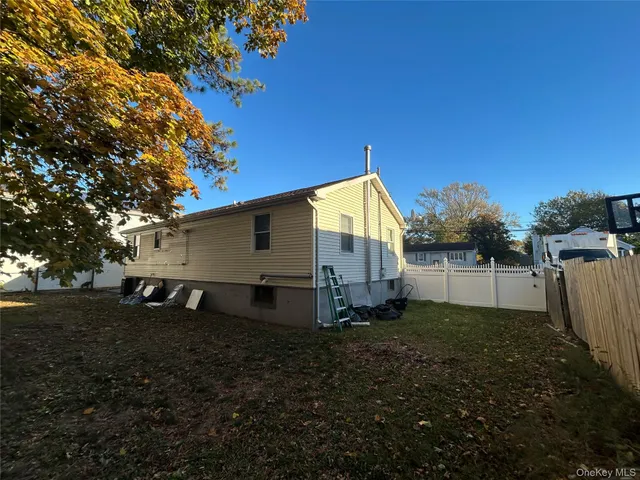 a view of a house with backyard and trees