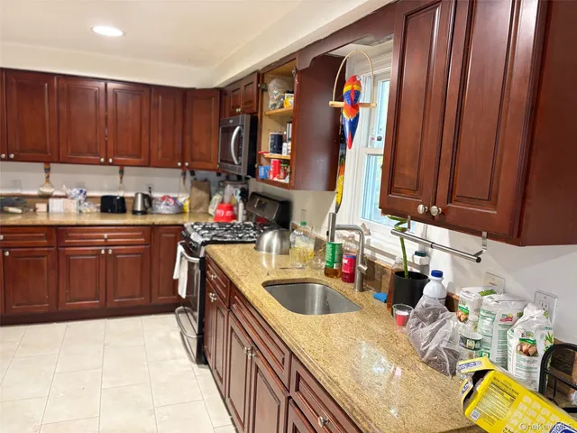 a kitchen with stainless steel appliances a sink dishwasher and cabinets with wooden floor