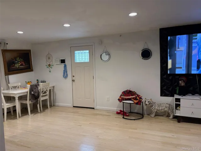 a living room with furniture a flat screen tv and gym equipment