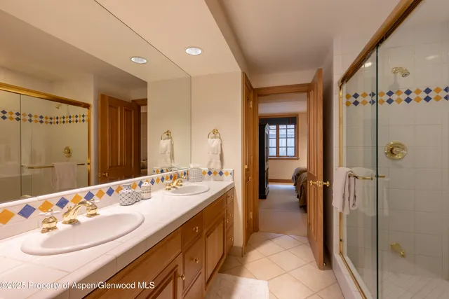 a en suite bathroom with a double vanity sink and a mirror
