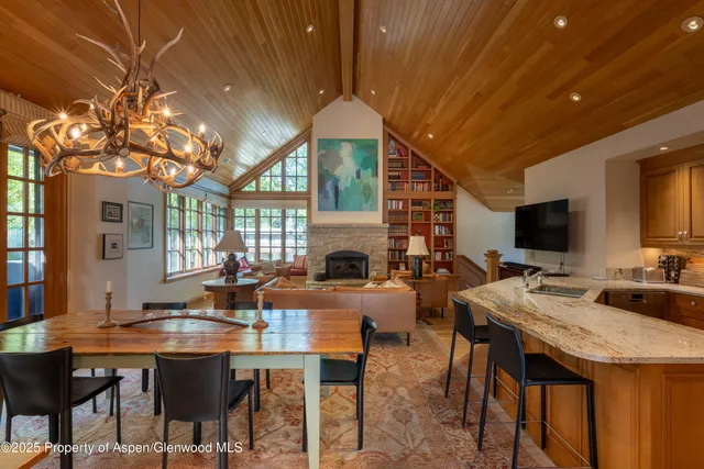 a view of a dining room with furniture a chandelier and wooden floor