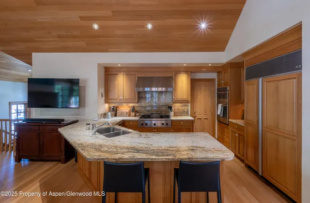 a kitchen with granite countertop kitchen island stainless steel appliances a sink and counter space