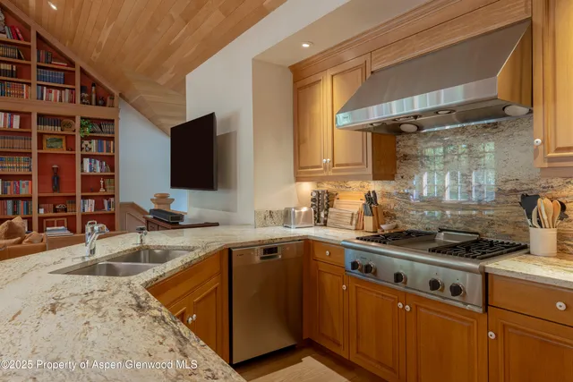 a kitchen with stainless steel appliances granite countertop a sink stove and cabinets