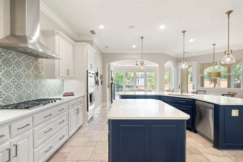 a large kitchen with kitchen island a sink a counter space and stainless steel appliances