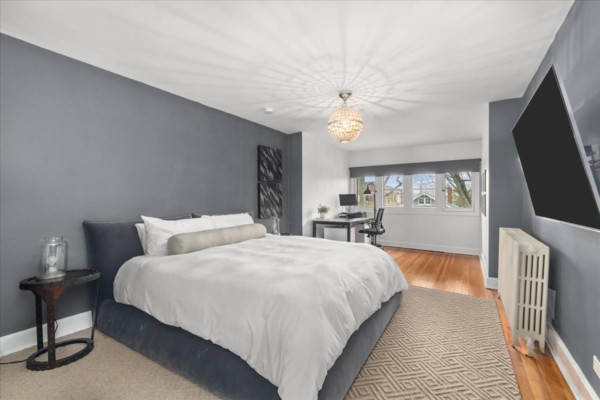 2087 West Greenleaf Avenue Chicago, IL 60645 - Photo 27 of 35 a bedroom with a large bed a chandelier and flat screen tv