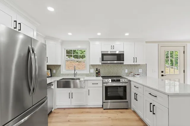 a kitchen with stainless steel appliances a refrigerator stove and sink