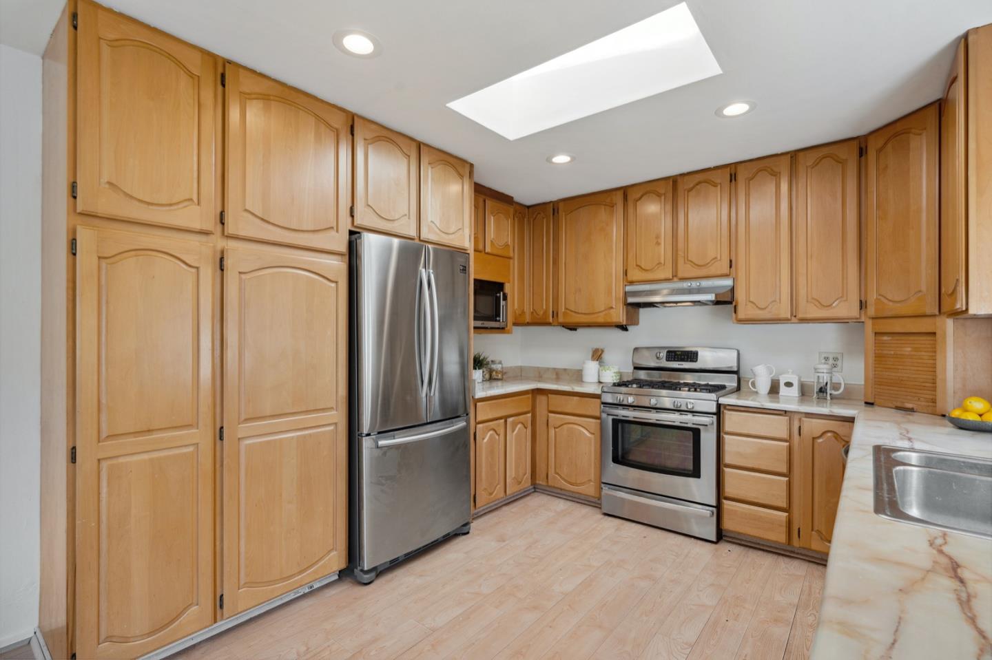 1060 Crespi Drive Pacifica, CA 94044 - Photo 13 of 32 a kitchen with granite countertop stainless steel appliances a refrigerator a stove top oven and cabinets