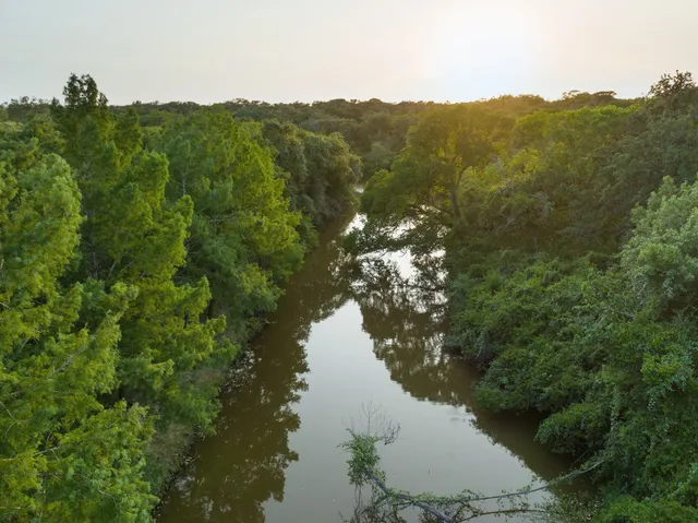 an aerial view of a house with a yard and lake view