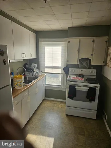 a kitchen with a stove a sink and a refrigerator