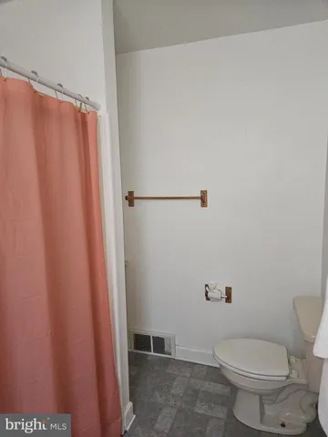 a white toilet sitting next to a shower