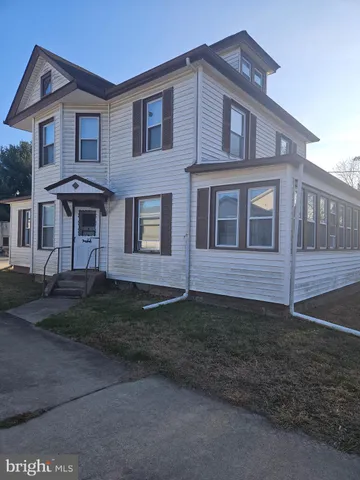 a view of a brick house with many windows and a yard