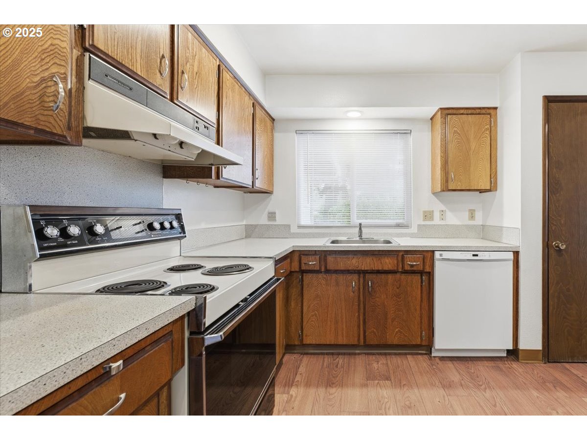 6760 Southwest 199th Court Beaverton, OR 97078 - Photo 12 of 44 a kitchen with stainless steel appliances granite countertop a sink a stove and cabinets