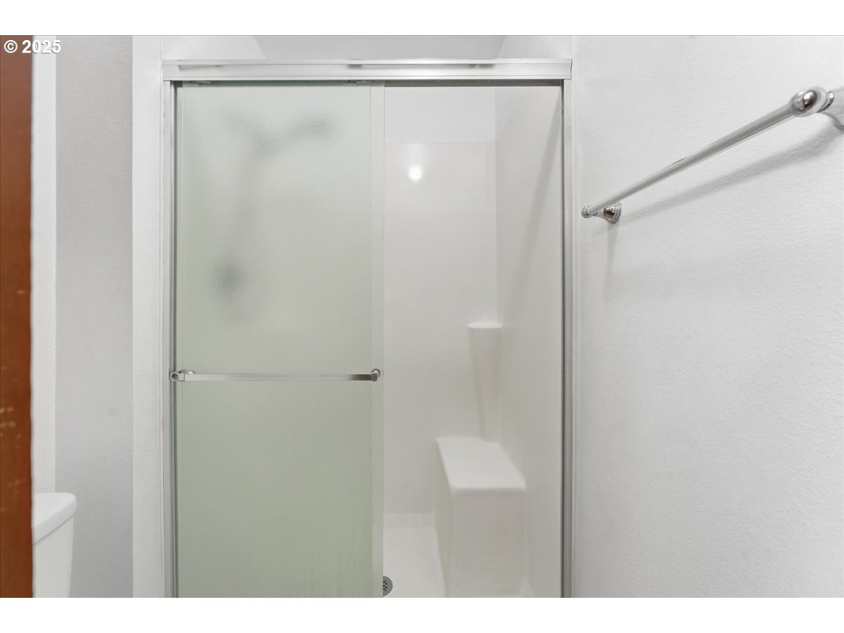 6760 Southwest 199th Court Beaverton, OR 97078 - Photo 20 of 44 a bathroom with a glass shower door