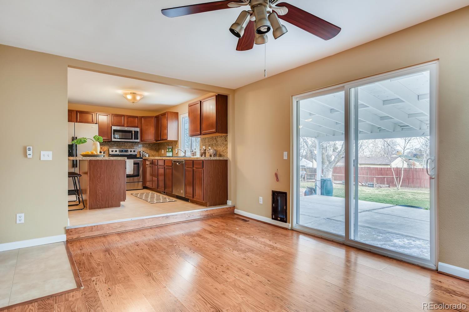 6734 Kendall Street Arvada, CO 80003 - Photo 13 of 36 a large kitchen with stainless steel appliances granite countertop a refrigerator and a sink