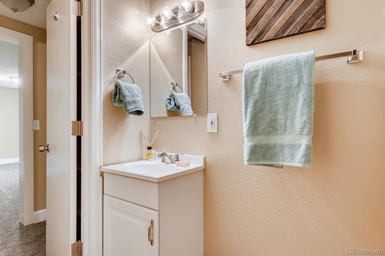 6734 Kendall Street Arvada, CO 80003 - Photo 22 of 36 a bathroom with a sink and mirror