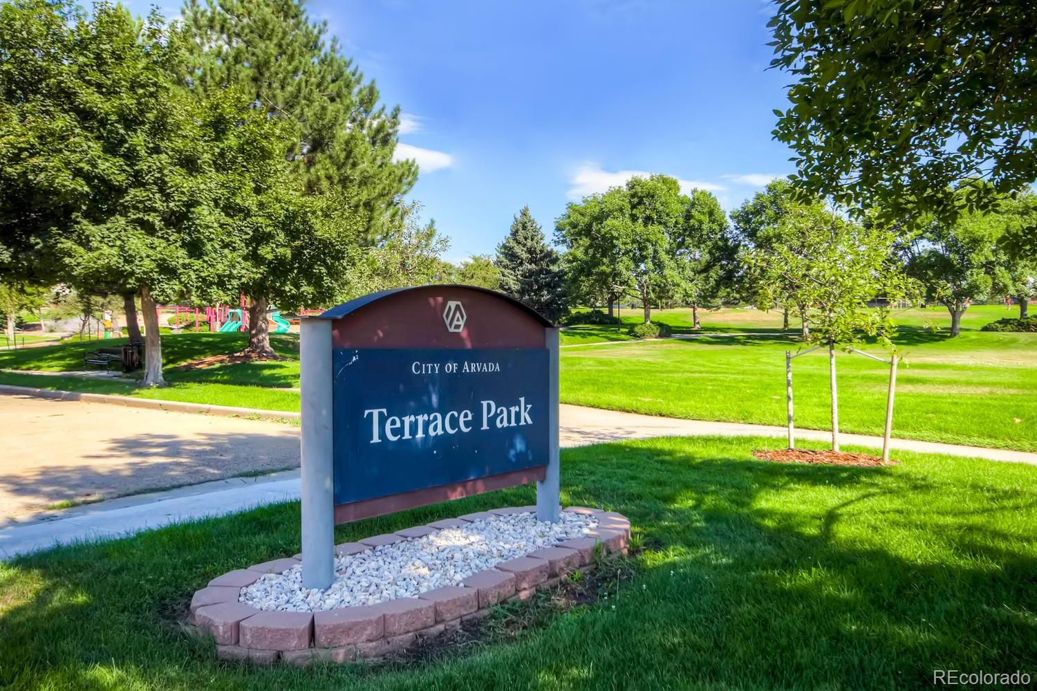 6734 Kendall Street Arvada, CO 80003 - Photo 36 of 36 a sign of golf club on a wall under a tree