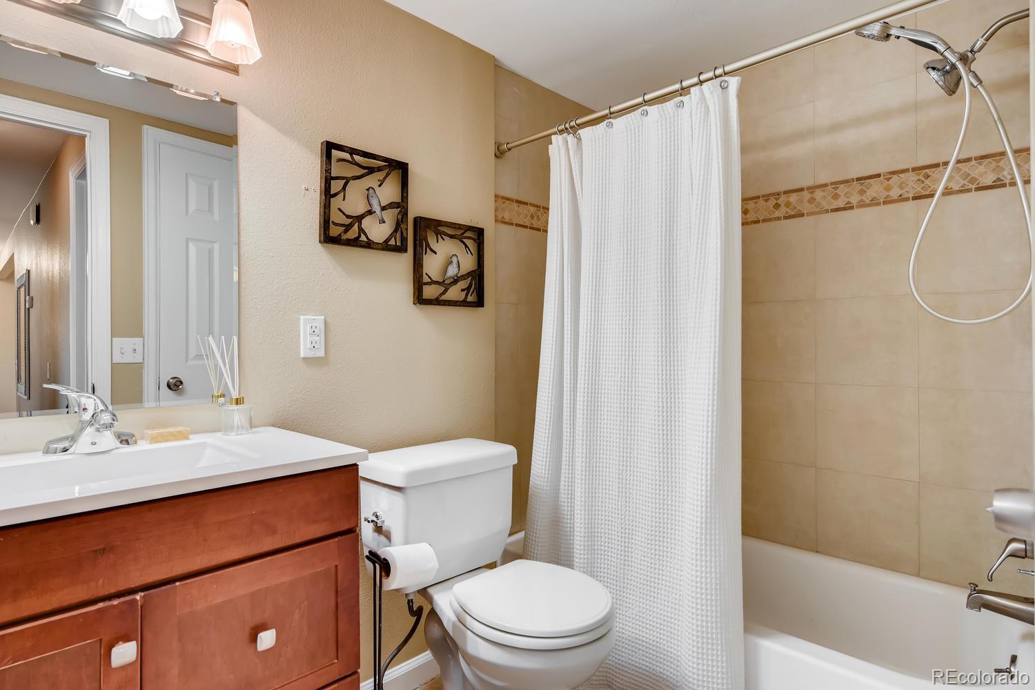 6734 Kendall Street Arvada, CO 80003 - Photo 5 of 36 a bathroom with a sink a toilet and shower
