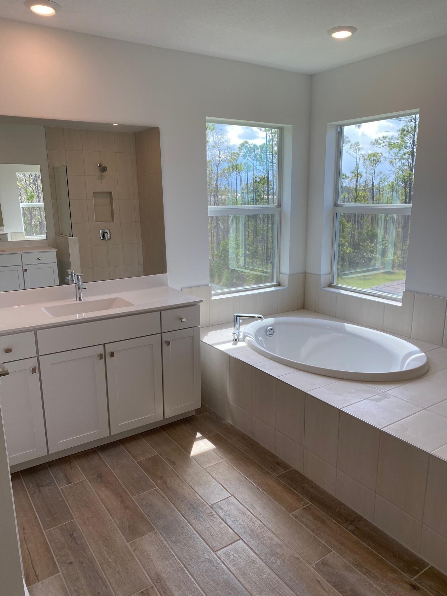 6830 Southeast Park Trace Drive Stuart, FL 34997 - Photo 15 of 20 a spacious bathroom with a granite countertop sink mirror and a bathtub
