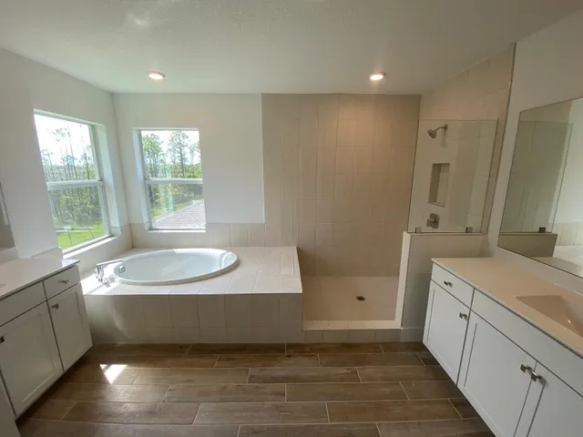 a bathroom with a tub sink and a mirror