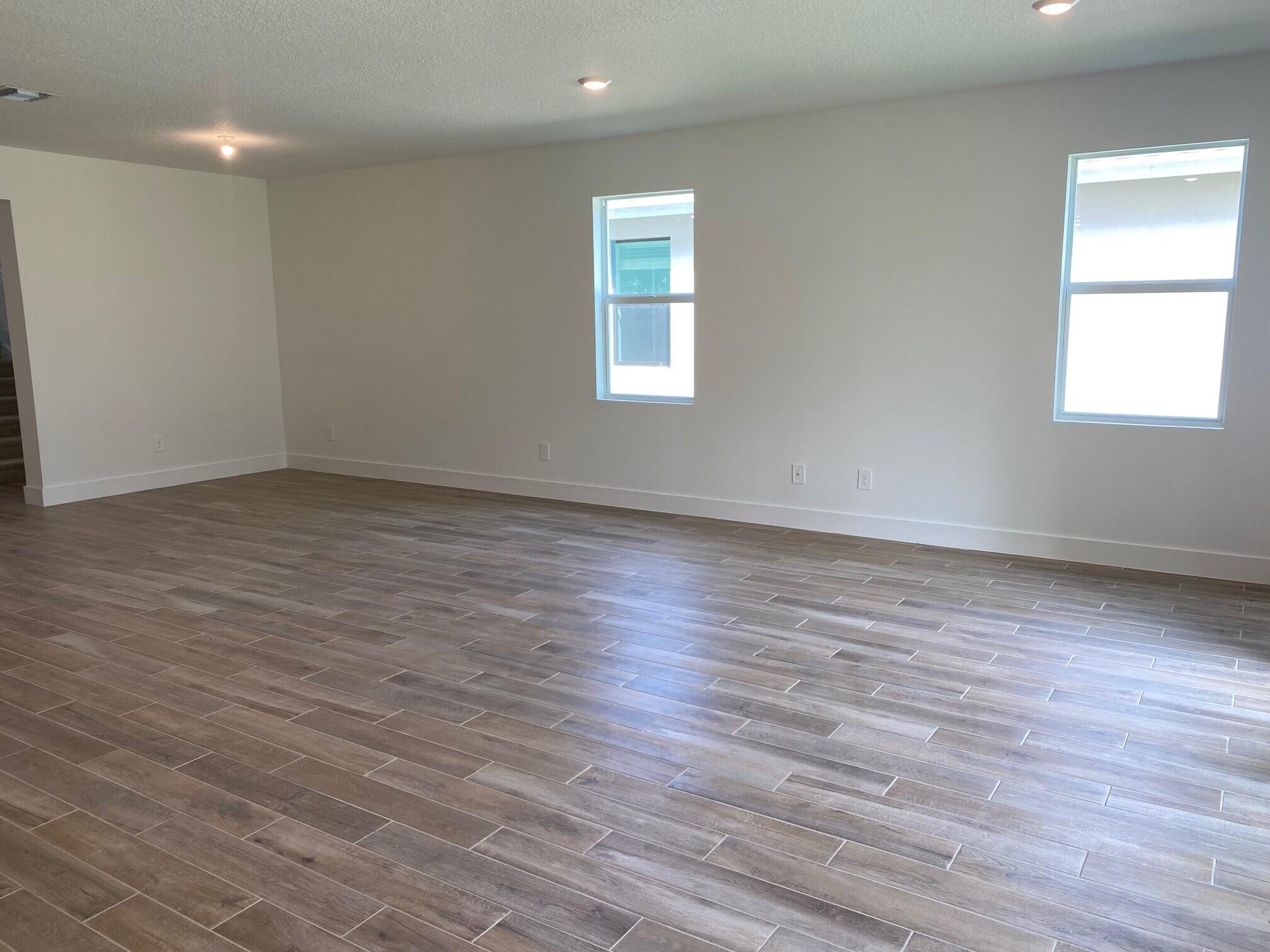 6830 Southeast Park Trace Drive Stuart, FL 34997 - Photo 6 of 20 an empty room with wooden floor and windows