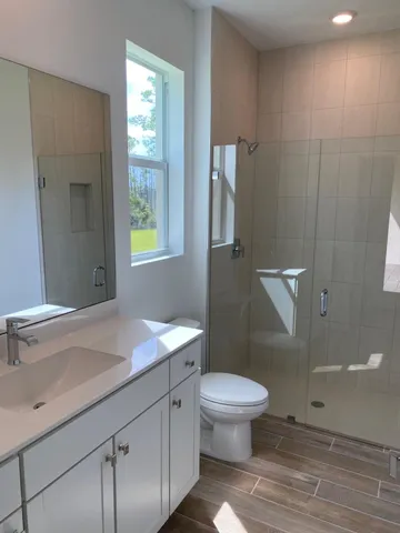 a bathroom with a sink a toilet and shower