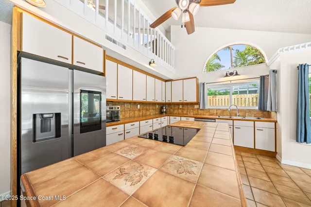 a kitchen with stainless steel appliances granite countertop a refrigerator a stove and a sink with cabinets