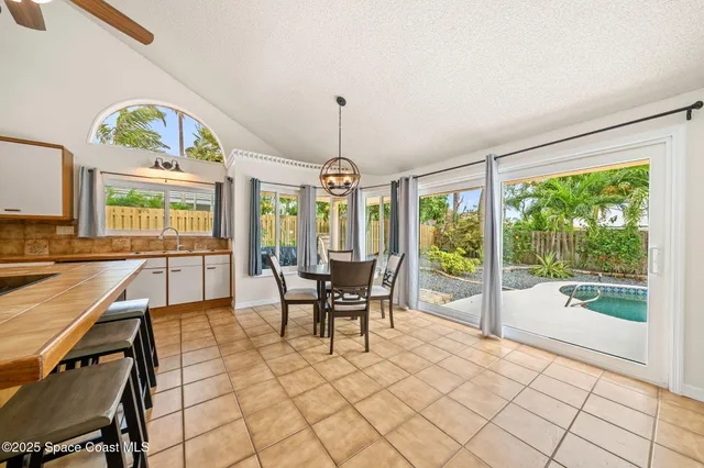 a dining room with furniture a chandelier and wooden floor