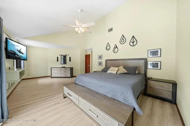 a spacious bedroom with a bed and a chandelier