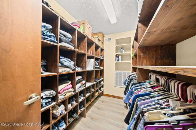 a view of walk in closet with clothes and shoes