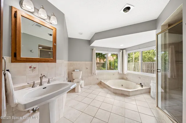 a bathroom with a tub sink and mirror