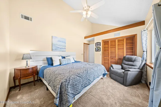 a bedroom with a bed couch and a large window