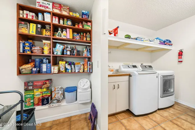 a utility room with fridge dryer and washer