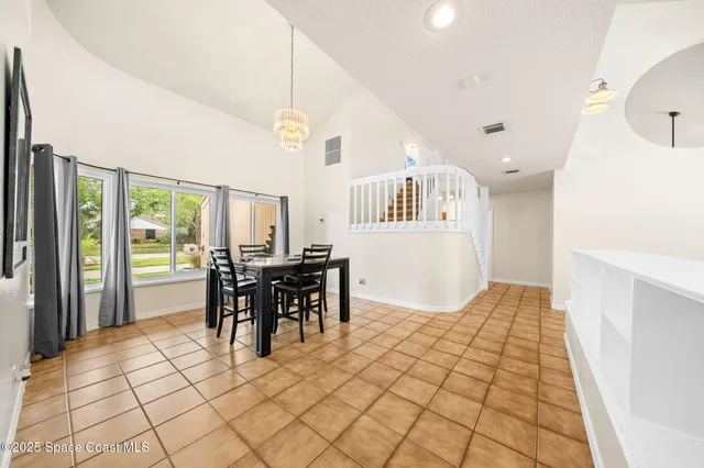 a view of a dining room with furniture and chandelier